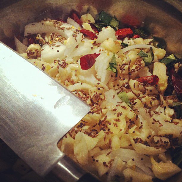 Julienne cut onions, minced garlic, dried red chilis, cumin seeds, black mustard seeds and curry leaves. 